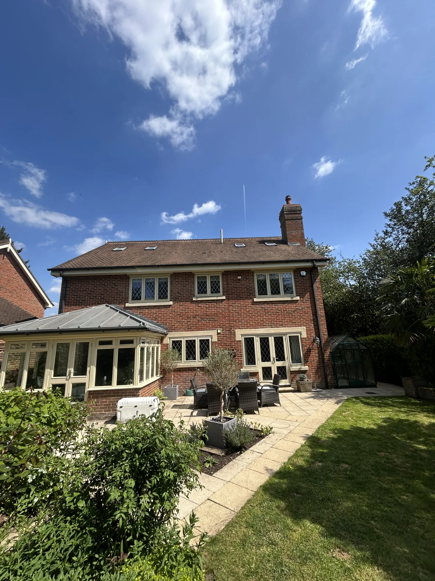 Cleaned house roof above a landscaped rear garden